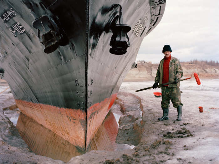 With his ship frozen in the Lena River in Zhigansk, sailor Vladimir Egorevich Kuchev  uses the opportunity to apply a fresh coat of paint. Fishing, hunting, and cattle breeding are the main occupations in Zhigansk.