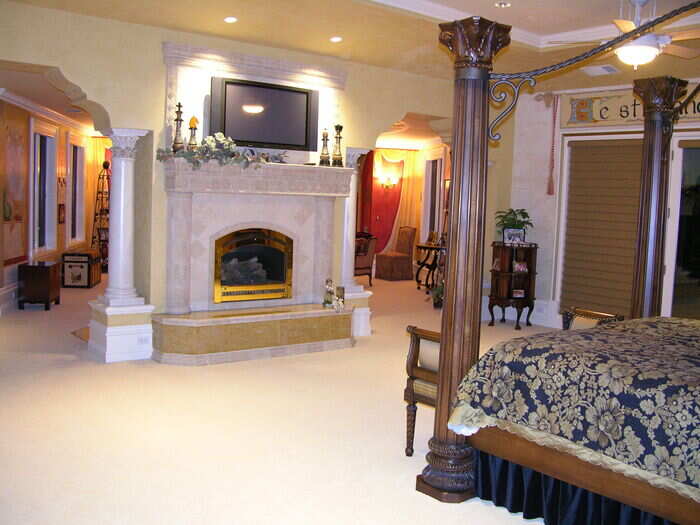 The master bedroom has a large fireplace right in between two columns.