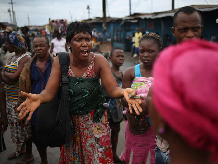 Liberians’ widespread distrust of the government has made containing the spread difficult. Many believe that the Ebola virus is a hoax, made up by the government to hide “cannibalistic rituals.” Here, a Liberian woman attempts to convince local residents that the epidemic is real.