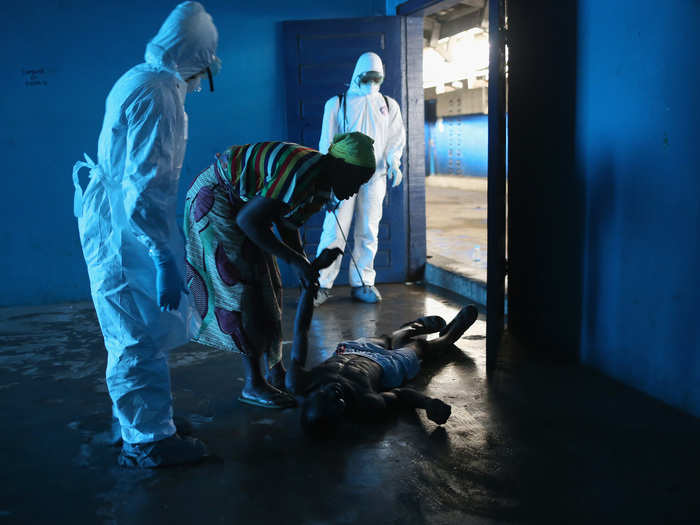 Many schools, like this one originally built by USAID, are being converted to Ebola centers. Here, a Liberian man suffering from Ebola has fallen in the ward and was knocked unconscious.