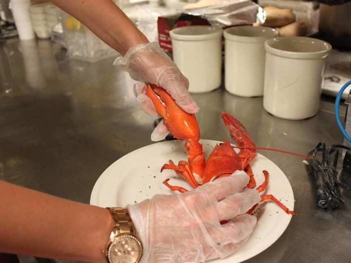 Once your lobster arrives, start by tearing off the claw. Hold the lobster down with one hand and twist the claw in one gentle motion with your other hand.