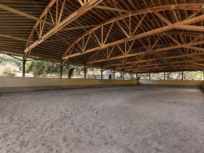 There are also outdoor paddocks, a trophy room, a covered riding arena, and an outdoor training track.