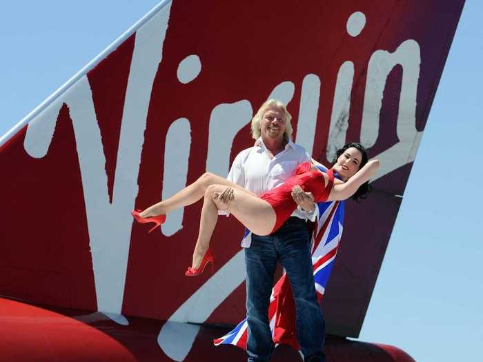 Branson is never one to turn down an opportunity for posing with a model, like he does here atop the tail of a Virgin Atlantic plane.