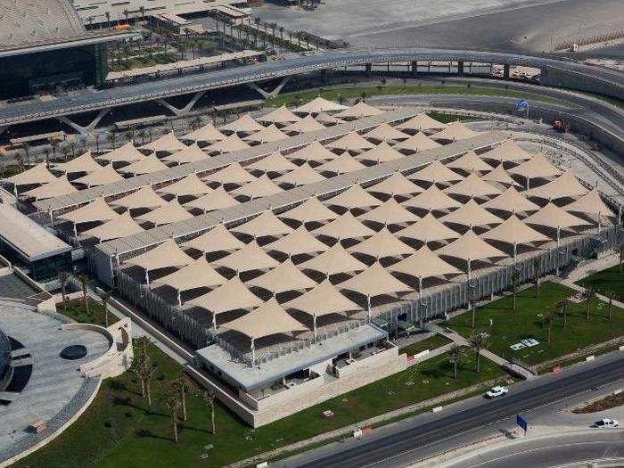 Cars are protected from the desert sun in a parking lot that features numerous covers.