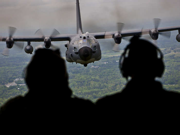 Aircrew members admire their MC-130E Combat Talon during the plane