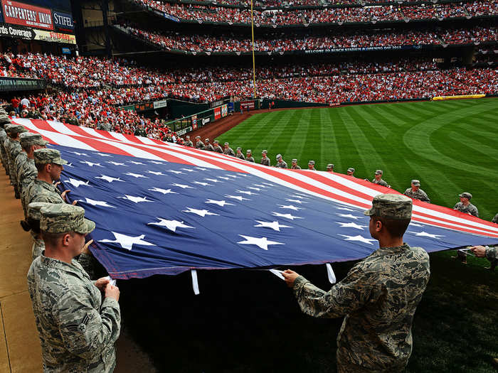 Airmen from the 375th Air Mobility Wing at Scott Air Force Base, Ill., present a giant American flag for nearly 50,000 fans at Busch Stadium, home of the St. Louis Cardinals.