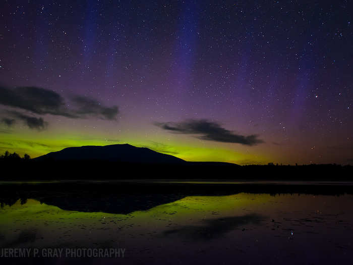 If you look closely, you can spot pillars of purple aurora shooting from the green-lit horizon and breaching the starry background in this image “Pillars”, which Gray shot west of Baxter State Park.