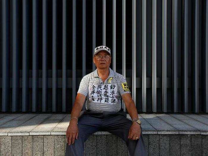 Chan Kin-hoi, 76, who is retired, poses for a photograph. Chan said, "I may change nothing, but I have to show my disagreement."
