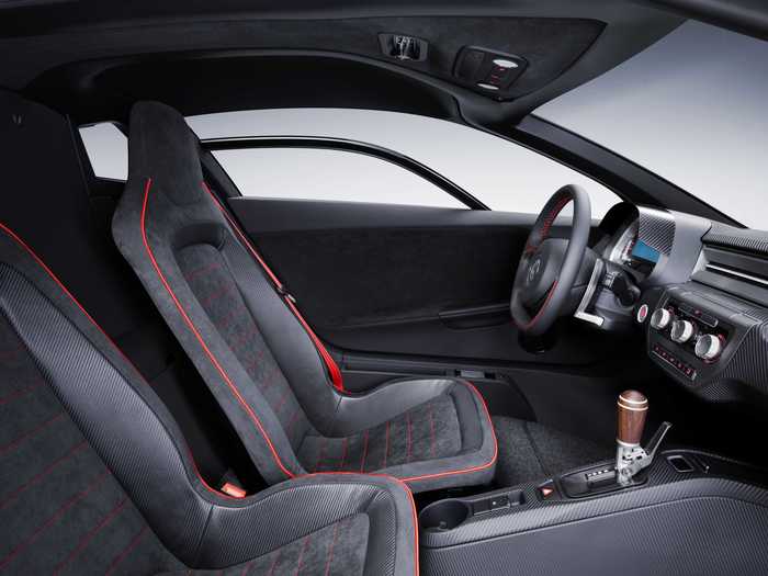 The interior is grey and racecar minimalist, but the wood shift handle is a nice touch — à la the Porsche Carrera GT.