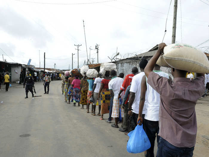 Many quarantined individuals were unable to pack adequate food and supplies before they were isolated. Here, relatives of the quarantined residents of West Point stand in line with food and other essential supplies for their relatives.