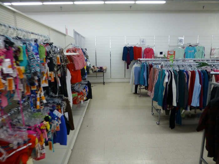 The walls are empty of aside from hanging clothes and swimsuits.