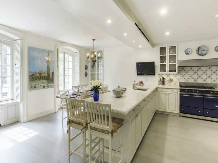 The kitchen has pristine white countertops and plenty of natural light.