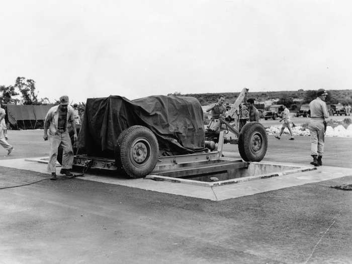 At the airfield, "Fat Man" is lined up over a pit specifically constructed for it, from which it is then loaded into the plane that eventually dropped it over Nagasaki.