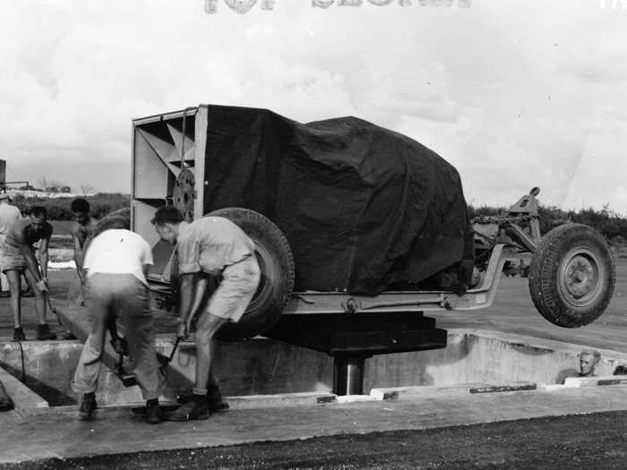 The bomb and its trailer are lowered down into the pit using a hydraulic lift.