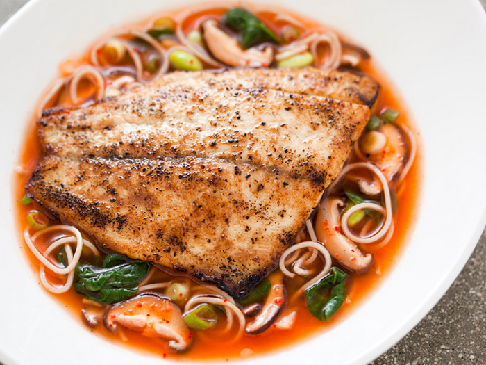 This is the 273-calorie Barramundi Noodle Bowl featuring sea bass with soba noodles, mushrooms, scallions, and edamame in kimchi broth.