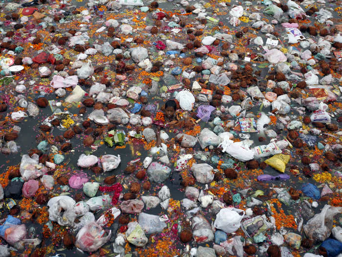 This boy swims in the garbage-infested waters of the Sabarmati River in Ahmedabad, India, looking for offerings thrown in by religious worshippers.