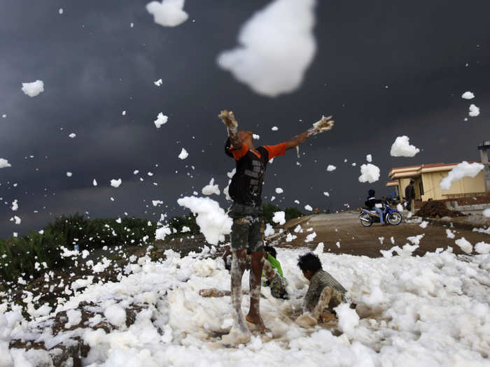 Children play in a foaming, polluted river in Jakarta, Indonesia.