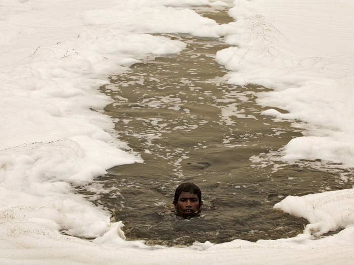 This boy swims through the sludgy Yamuna River in New Delhi, India.