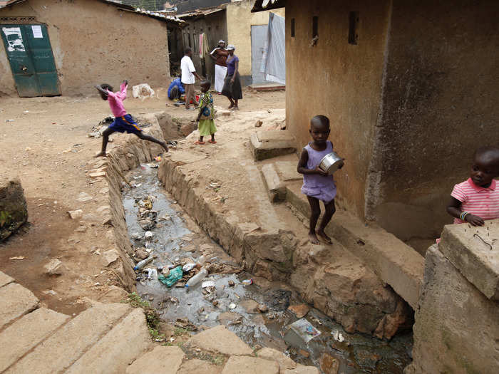 These children play at the edge of an open sewer in Kampala, Uganda.