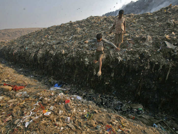 This boy jumps over a puddle of toxic liquid at the Ghazipur landfill in New Delhi, India.