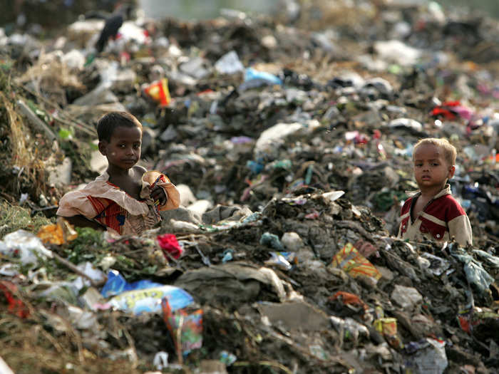 These children stand waist-deep in a garbage heap outside New Delhi, India.