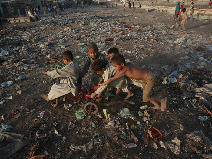 Children play amongst the garbage in a slum area of Karachi, Pakistan.