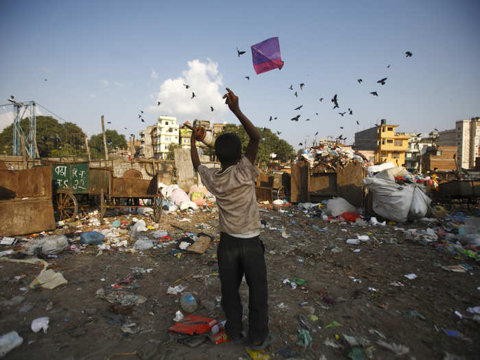 This boy flies his kite over a dumping site at the Bishnumati River in Kathmandu, Nepal.