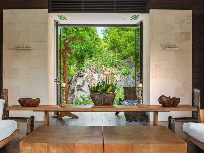 Inside, the home has cedar and coral stone walls, walnut flooring, and art from Bali and Africa.