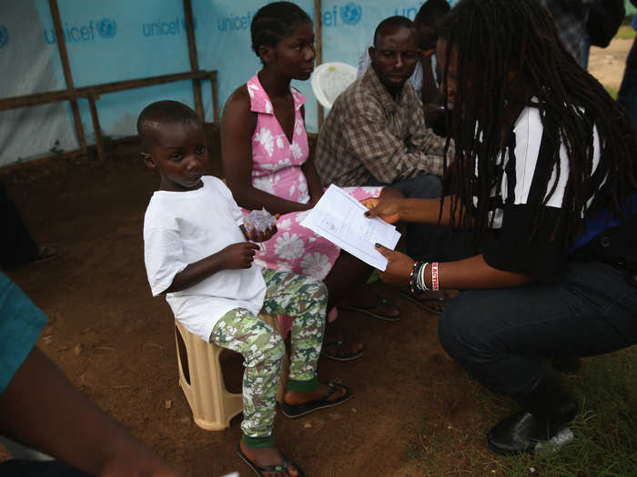 This 5-year-old, Abrahim Quota, is given a letter to confirm that he has recovered from the virus that took his parents. After leaving this clinic in Monrovia he will stay with relatives.