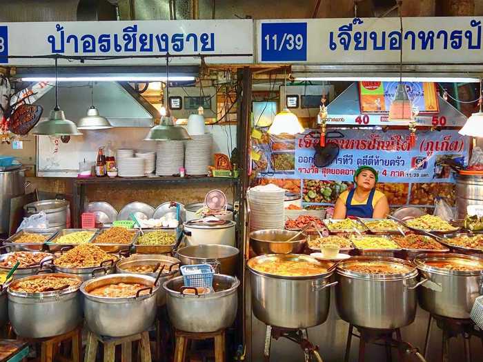 Sample authentic local street food—satay, pad Thai, fried fish—in Thailand.