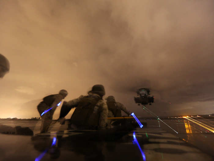 Marines participate in an external load lifting exercise with a CH-53E Super Stallion helicopter.