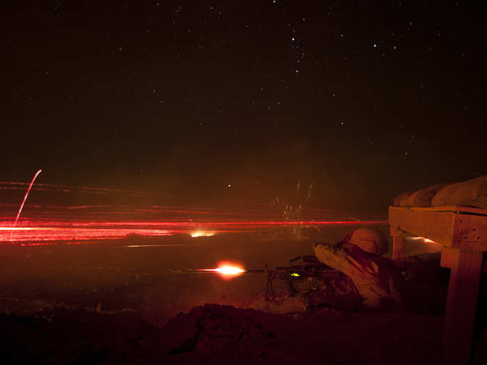 Machine gunners with Lima Company, 3rd Battalion, 3rd Marine Regiment, illuminate the night sky by firing tracer rounds and then reloading their weapons at a training exercise in California.