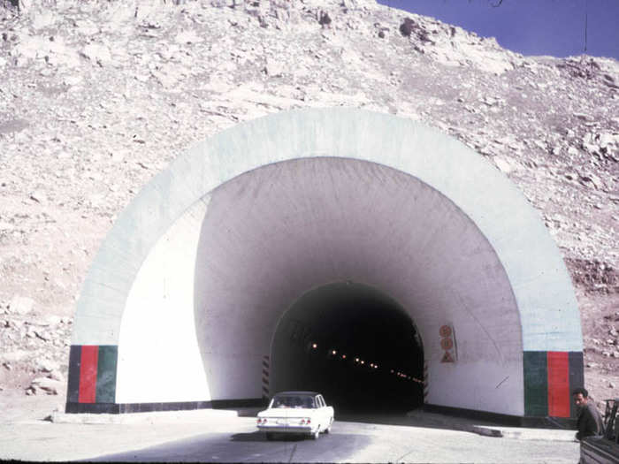 A new car drives through a freshly-built mountain tunnel ...