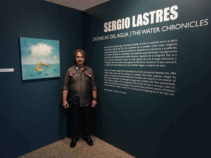 Sergio Lastres, 49, poses at an exhibition of his work based on the 1994 Cuban raft exodus. Lastres and his wife were among 15 migrants rescued when their raft filled with water in 1994. They were taken to Guantanamo Base where he painted his first work about rafters, he said.