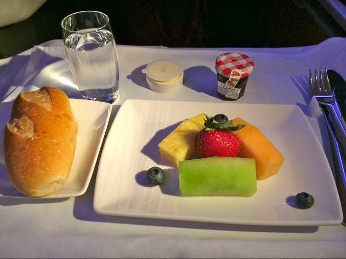 For breakfast, passengers might start with some fresh fruit and bread with butter and jam.