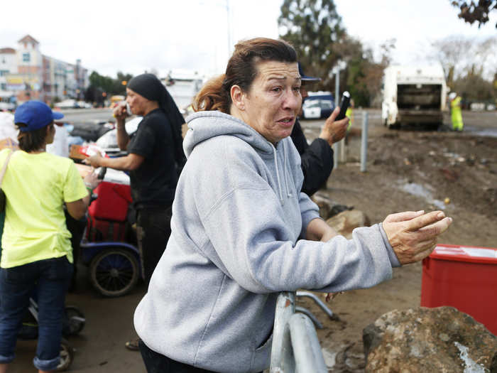 Resident Tracy Sanchez stands behind barricades that had been put up around the area and pleads to be let down to get her belongings.