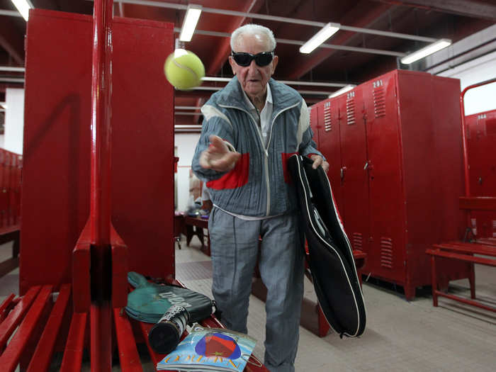 Artin Elmayan throws a tennis ball in the locker room before playing tennis at the River Plate stadium in Buenos Aires September, 2012. Elmayan, who emigrated to Argentina from Europe when it was on the verge of war in 1938 at the age of 21, said he took up tennis as a hobby and has never looked back. Now, at 95, he is the world