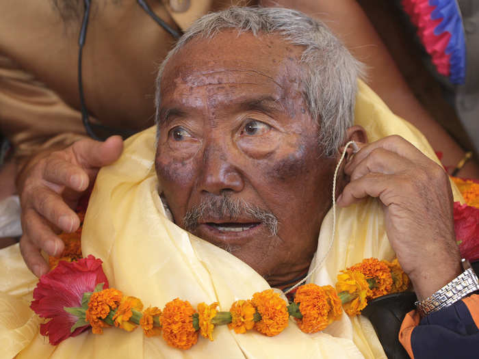 Min Bahadhur Sherchan, a 76-year-old Nepali, adjusts his hearing aid while talking with the media after arriving in Kathmandu from the Everest region May, 2008. At the time, Sherchan was the oldest person to climb to the top of Mount Everest.