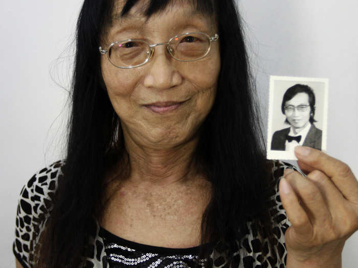 Qian Jinfan, an 84-year-old transsexual who prefers to be addressed as "Yiling," holds up a photo taken at the age of 59, in China