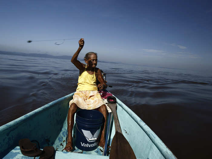 Cecilia Villegas, 77, throws a fishing line along the sea of the Pacific coast of Cano Ciego Island near Puntarenas, Costa Rica, in October 2012. Villegas leaves her home in Cano Ciego Island every morning to fish, which is her only means of survival.