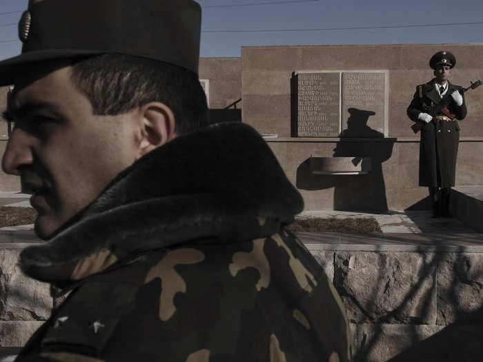The breakaway war with Azerbaijan ended in 1994 with an estimated 30,000 dead and nearly 750,000 displaced Azerbaijanis. Below, NKR soldiers stand guard at a war memorial in Kharamort, a village that was once evenly populated by ethnic Azeris (Azerbaijani people) and Armenians, but shrunk to half that size after Azeris fled and their homes were burned.