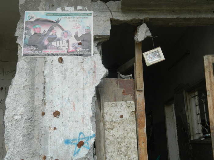 A poster of a fallen Hamas fighter is tacked to a ruined facade in Shujaiah, a neighborhood in eastern Gaza City that was the site of the heaviest combat of the war.