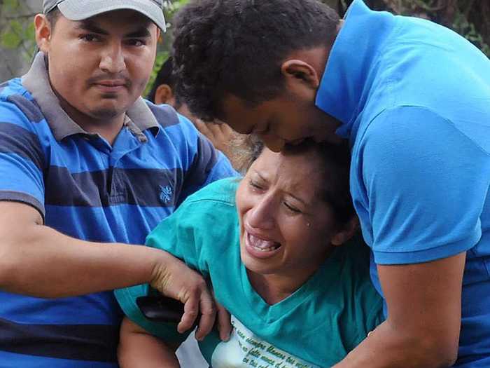 Drugs trafficked by violent gangs fuel much of the conflict. Here, a woman sobs after "hooded criminals" shot nine people outside a morgue in August 2014. The vast majority of murders in the city go unsolved.