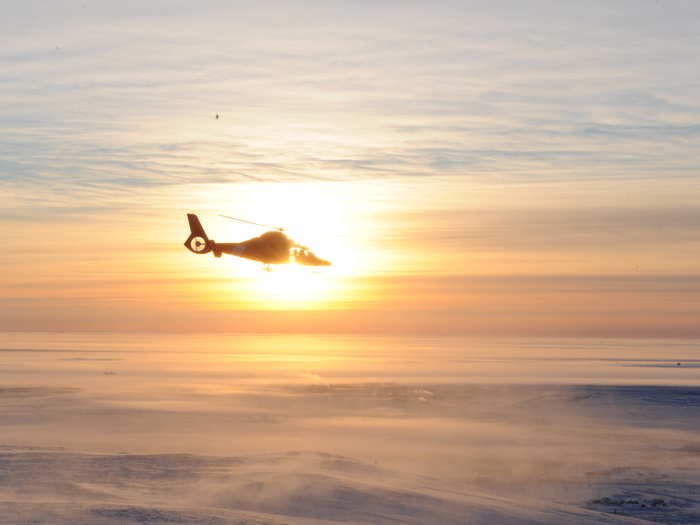 Cutting through the ice is a multi-team process. Here, a Coast Guard MH-65 Dolphin helicopter ascends from Nome after providing ice reconnaissance during the escort of the Russian tanker.