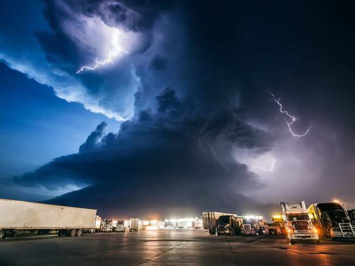 Mike Hollingshead makes a living following the worst storms in America, from snarling tornadoes chewing up the Kansas farmland to supercell thunderstorms massing over the Dakotas. This supercell photograph was taken at a York, Nebraska truck stop after a day of chasing storms.