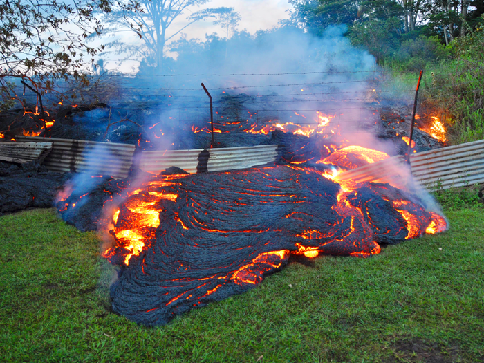 A slow-moving river of molten lava from an erupting volcano crept over residential and farm property on Hawaii