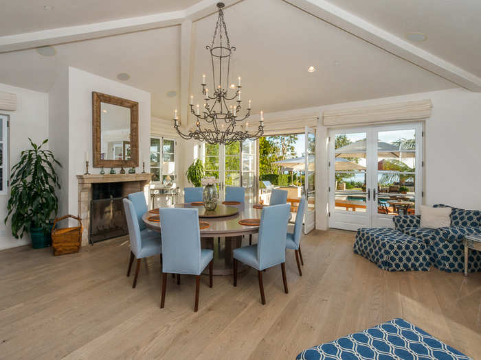 The nearby dining room also has gorgeous views of the ocean, a chandelier, and fireplace.