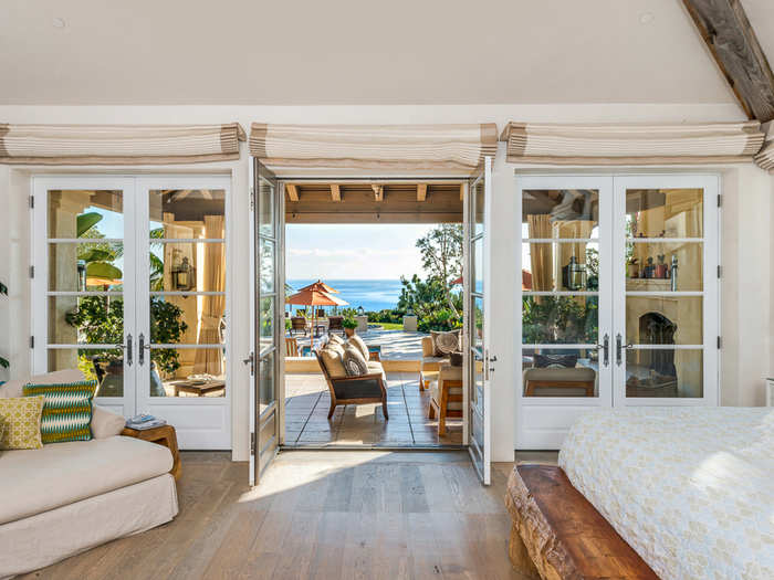 The master bedroom is a suite with a fireplace and french doors that open outside.