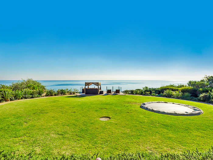 The landscaped backyard is huge with an in-ground trampoline (for safety).