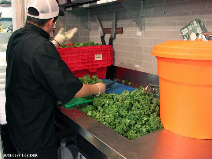 Workers spend hours chopping mounds of kale for the lunchtime crowd.